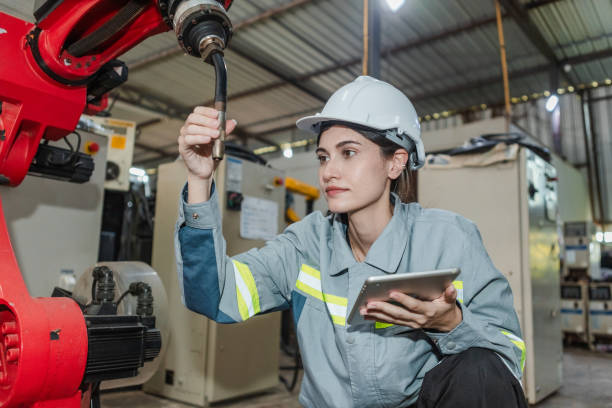 istock Female technician engineer checking automation robotics arm at industrial modern factory. woman working at factory innovation automation robot. Maintenance department, robots used in industrial. 1619833762