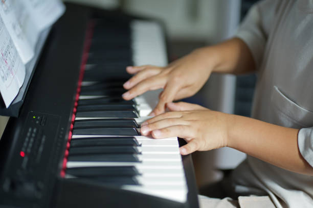 istock Clodeup hand of a  boy playing electric piano 1619918326
