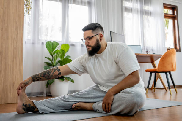 Latin man practicing yoga at home