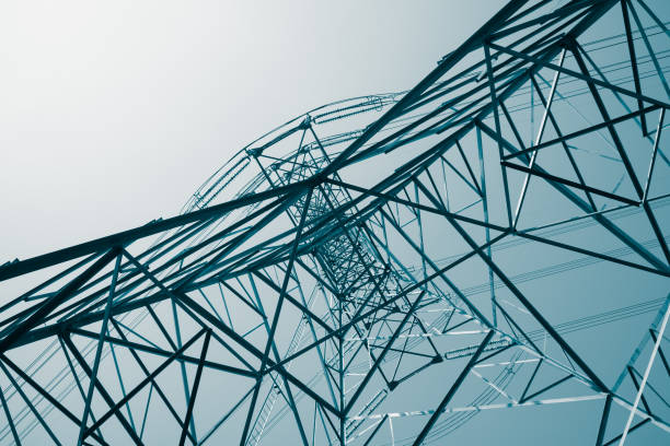 istock Abstract pattern from bottom view of high voltage pole power transmission tower with clear sky sunny day background. 1619959322