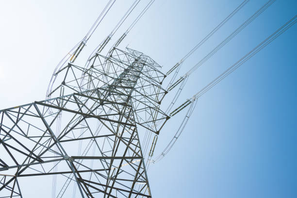 istock High voltage power electricity post on with blue sky background sunny day from bottom view. 1619960365