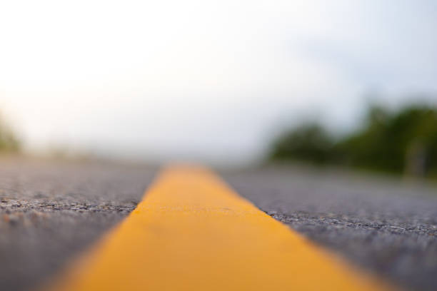 istock paved road with yellow road lines 1619972418