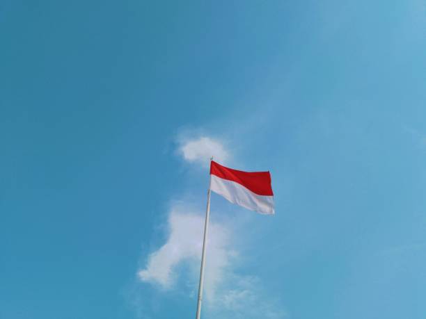 istock Indonesia's flag is fluttering by wind with a wonderful blue sky background. Close-up, low angle view. Indonesia's Independence day. 1619974268