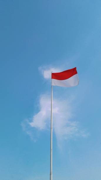 istock Indonesia's flag is fluttering by wind with a wonderful blue sky background. Close-up, low angle view. Indonesia's Independence day. 1619974270