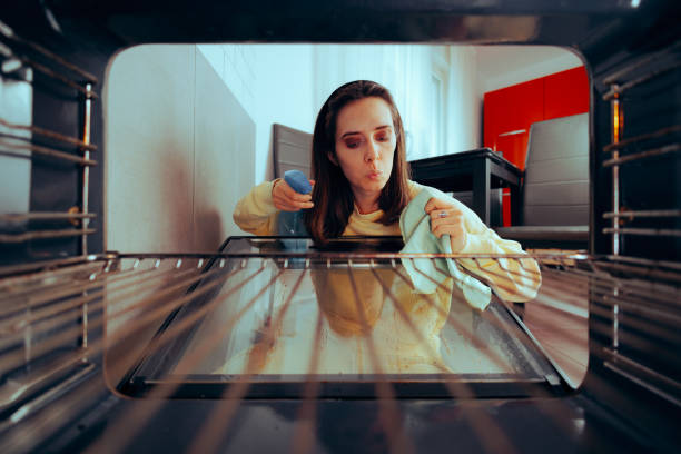 istock Funny Woman Cleaning Her Oven Using a Spray Detergent 1619990312