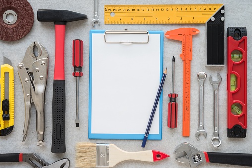 Flat lay of vary many set of hardware tools equipment, home DIY, fix repair, building construction, garage, carpenter, technician and paper clipboard on white gypsum board background. Tools shop, hardware house, DIY concept.