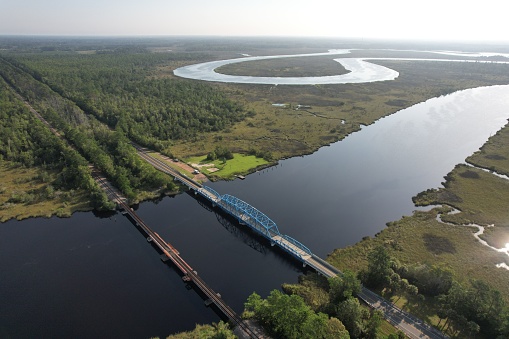 An aerial view of a bridge on a tranquil river on a sunny day