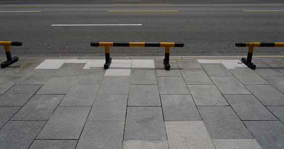 Closeup of yellow and black steel bollards that restrict movement of cars