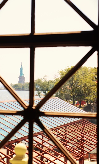 Picture of Statue of Liberty taken from the Ellis Island Museum window.  Ellis and Liberty islands are famous tourist locations in New York and New Jersey