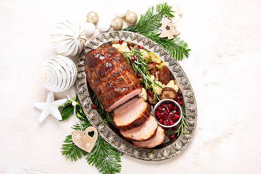 Christmas composition with baked ham on white background. Traditional food concept. Top view.