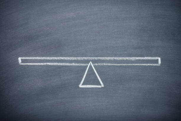 istock Flat lay of drawing empty seesaw or balance scale in equilibrium on chalkboard background. 1620056839