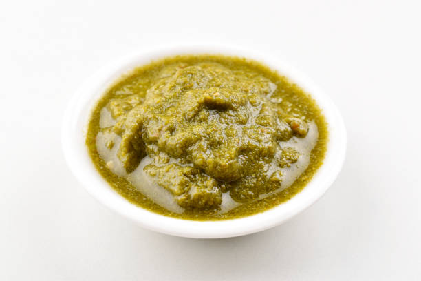 Indian style green chutney in bowl on white background