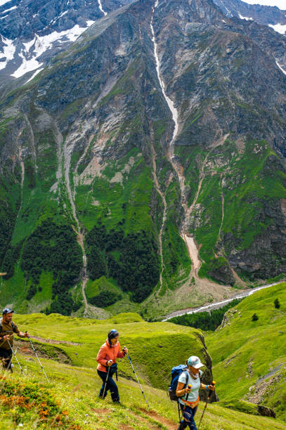 senderismo de montaña. los excursionistas con bastones de trekking suben empinadas en el sendero de montaña. paisaje de montaña. turismo, concepto de estilo de vida deportivo - rocky mountian fotografías e imágenes de stock