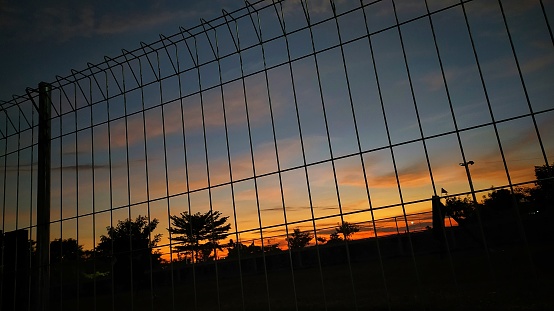 Twilight sky from behind the fence