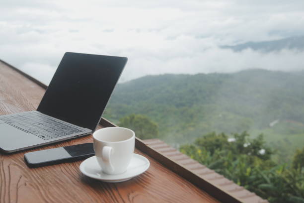 istock Young man freelancer traveler wearing hat anywhere working online using laptop and enjoying mountains view 1620198680