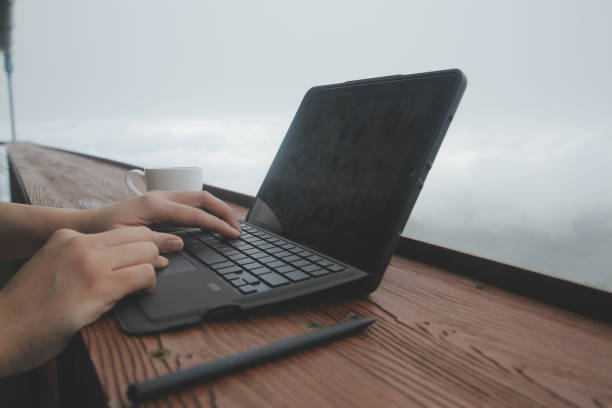 istock Young man freelancer traveler wearing hat anywhere working online using laptop and enjoying mountains view 1620198692