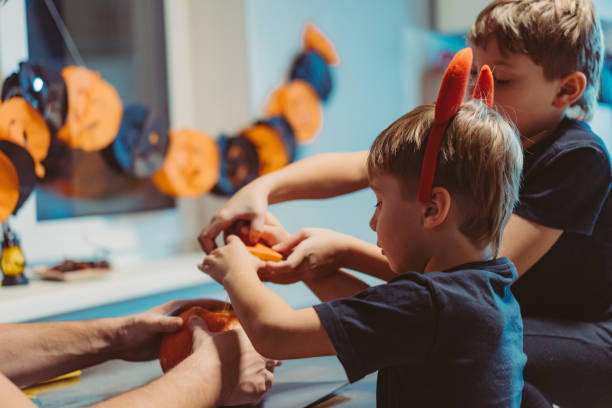 istock Children with father carving a traditional Jack lantern from pumpkin 1620212693