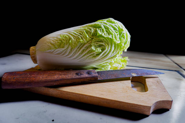 istock chicory and a knife on a wooden tray with a black background. 1620213758
