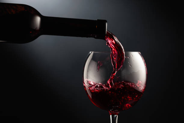 istock Pouring red wine into a wine glass. 1620220257