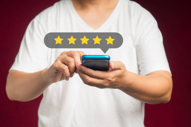 istock Satisfaction and feedback surveys. A man in a white casual using a smartphone gives the five-star icon a rating of very impressed for service while standing over a red background 1620226140