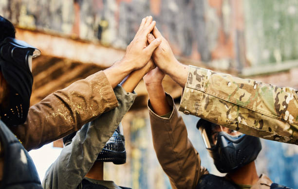 istock Motivation, paintball team or hands high five on a mission, friends or soldier training on war battlefield. Goals, target success or people with support in partnership or military group solidarity 1620264875