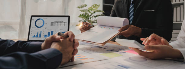 istock Business People Meeting using laptop computer,calculator,notebook,stock market chart paper for analysis Plans to improve quality next month. Conference Discussion Corporate Concept. 1620295686