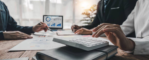 istock Business People Meeting using laptop computer,calculator,notebook,stock market chart paper for analysis Plans to improve quality next month. Conference Discussion Corporate Concept. 1620295895