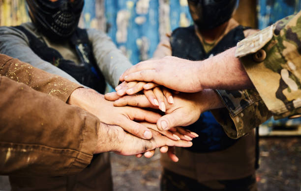 istock Motivation, team building or hands in huddle on a mission, strategy or soldier training on paintball battlefield. War goals, collaboration or army people with support in partnership or military group 1620299427