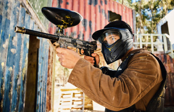 istock Paintball, target practice or man with gun in shooting game playing with on fun battlefield mission. Aim or focused male soldier with army weapons gear for survival in military challenge competition 1620299437