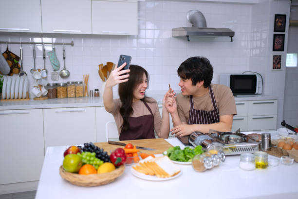 istock Young couple is livestreaming in kitchen. 1620318964