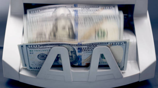 istock Dollars on money counting machine. Electronic financial calculation system. 1620321137