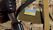 Ukrainian soldier in military uniform with a flag and a chevron depicting the flag of Ukraine and the national symbol