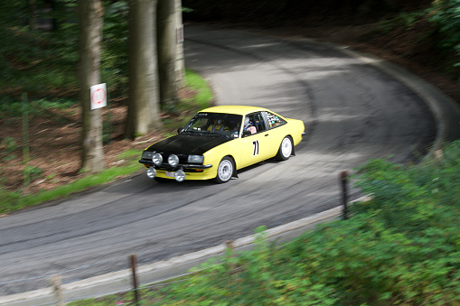08 13 2023 Theux Belgium. Old mythical 1979 opel kadett gte driving at full speed on a country road in a Belgian race called (the climb of the maquisard) with a motion blur.