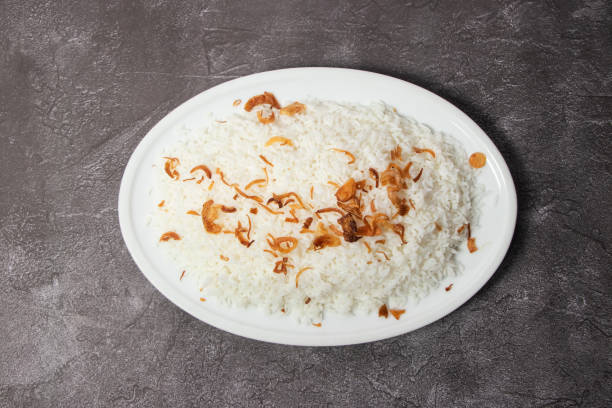 バングラデシュ料理の上面図の背景に、プレーンポラオまたはフライドオニオンとゆでたプラオライスを皿に添える - onion portion onion ring isolated ストックフォトと画像