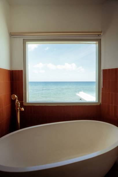 istock Modern Bathroom with Bathtub Large Window Overlookig the Ocean 1620337941