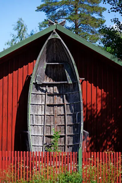 large old wooden boat leaning against house wall