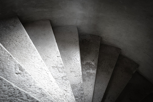 Close up shot of a stone spiral staircase in a French building, selective focus