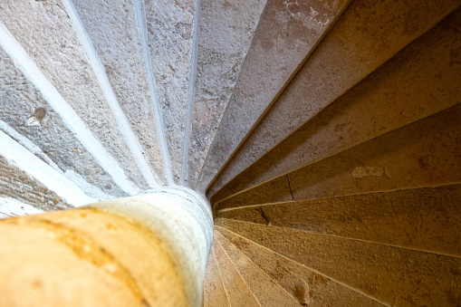 Close up shot of a stone spiral staircase in a French building, selective focus