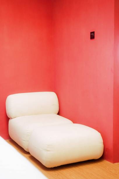 istock Rounded Sofa at the Corner of a Red Wall Room 1620351708