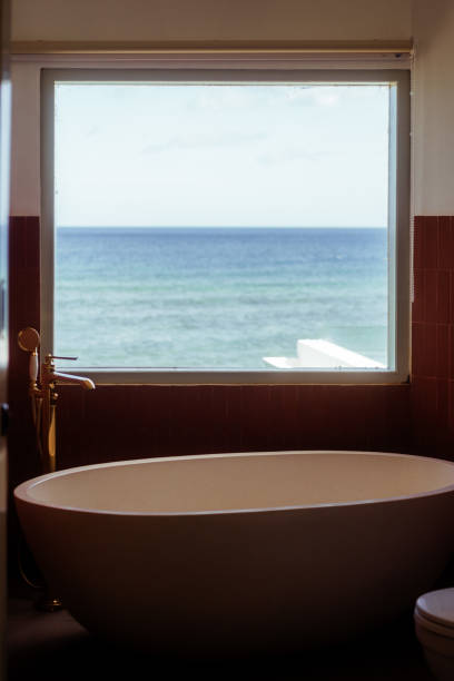 istock Modern Bathroom with Bathtub Large Window Overlookig the Ocean 1620352061