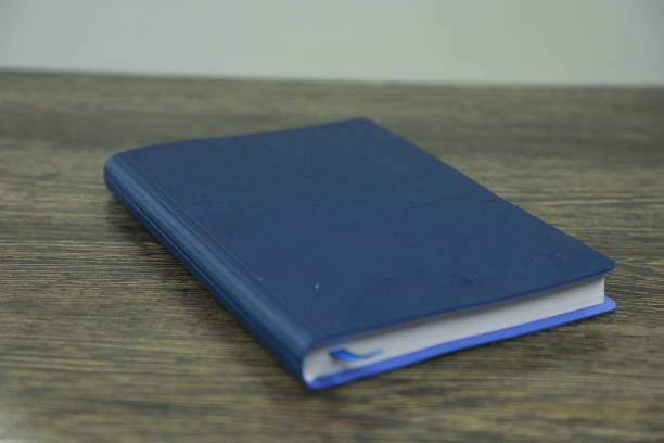 Blue book on the wooden table. Selective focus and shallow depth of field.