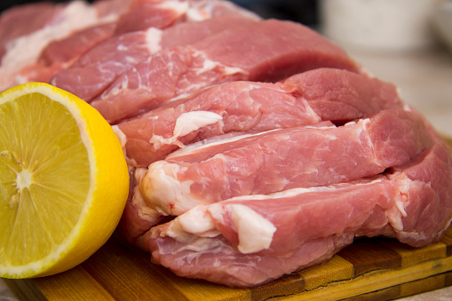 Pork meat slices prepared for cooking steak on the wooden desk