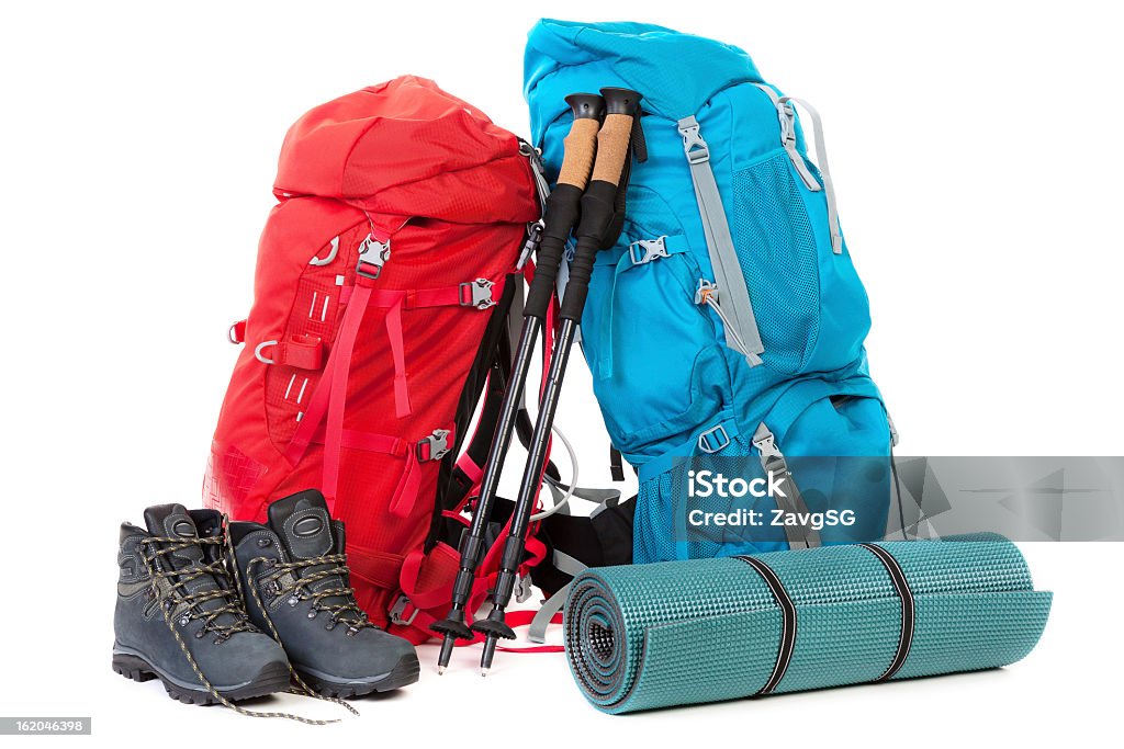 Hiking gear with a red and a blue backpack shoes and a mat Hiking gear, isolated over white background Hiking Stock Photo