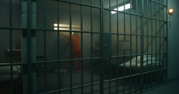 istock Female prisoner in orange uniform walks in jail cell 1620469233
