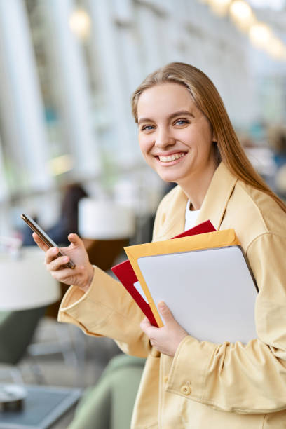 istock Happy girl student using mobile phone looking at camera, vertical portrait. 1620472023