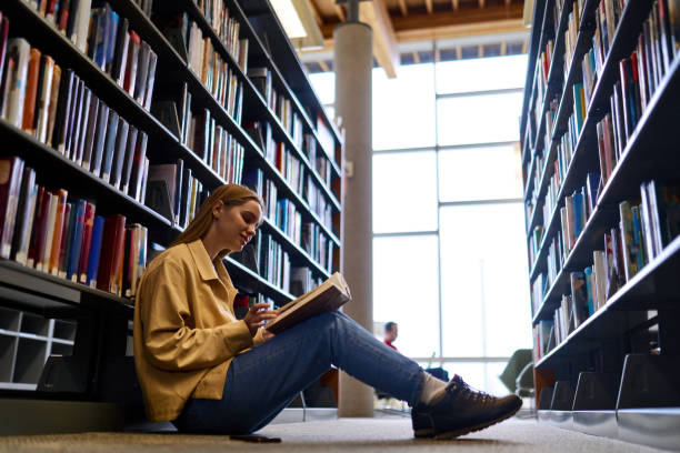 istock Smart girl student holding book sitting in university library or bookstore. 1620472568