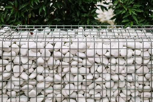 Gabion baskets with white stones used as a fence
