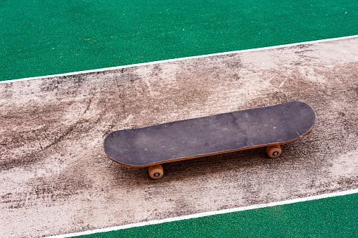 An image shows a skateboard placed on a skateboard track in a stadium.