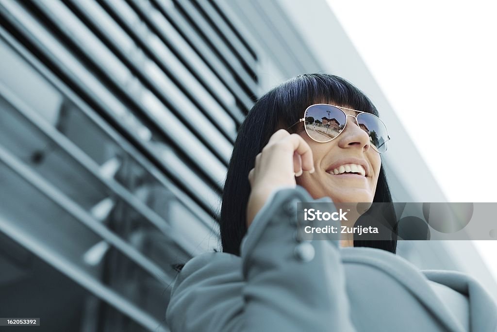 Mujer de negocios con teléfono celular en frente del edificio de oficinas - Foto de stock de Adulto libre de derechos
