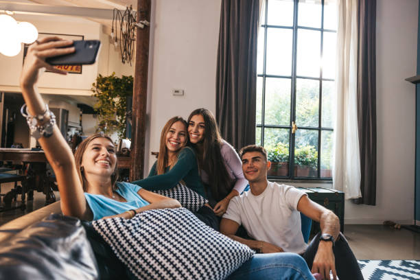 istock Four friends relaxing on the couch and taking a selfie 1620545762